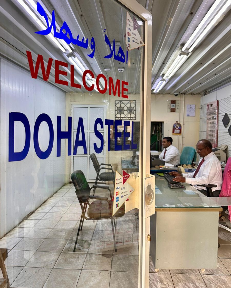 Main entrance of Doha Steel showroom with Welcome and أهلاً وسهلاً lettering on the glass, staff at the front desk